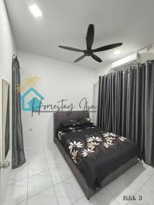 um quarto com uma cama e uma ventoinha de tecto em Homestay Ibu em Lumut