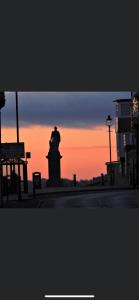 una silueta de una estatua frente a una puesta de sol en Village view apartments en Tynemouth