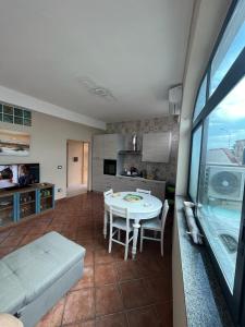 cocina y sala de estar con mesa blanca en Vista Eolie Milazzo- Apartments, en Milazzo