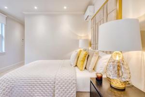 Marble Arch Suite 3-Hosted by Sweetstay في لندن: غرفة نوم بسرير ومصباح على طاولة