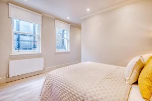 a bedroom with a bed and two windows at Marble Arch Suite 3-Hosted by Sweetstay in London
