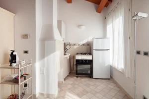 y cocina con nevera y fogones. en La Casina apartament, en Ferrara