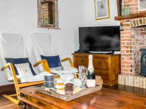 a living room with a coffee table and a tv at Whitestones Cottage in Caister-on-Sea