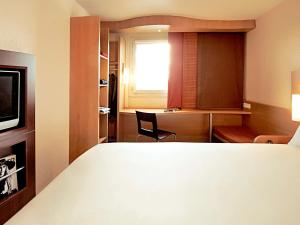 sypialnia z łóżkiem, biurkiem i oknem w obiekcie Hotel Ibis Lisboa Sintra w mieście Sintra