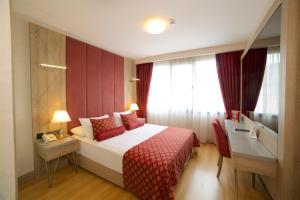Aspen Hotel & SPA Istanbul Old City في إسطنبول: غرفه فندقيه بسرير ومكتب ونافذه