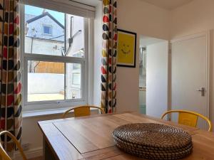 a dining room table with a large window at Mona Lodge - 3 bed cottage in Llandudno in Llandudno
