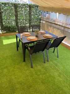 - une table de pique-nique avec 2 chaises sur l'herbe dans l'établissement Green Oasis Apartment, à Alexandroúpolis