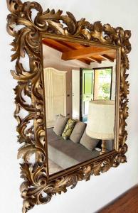um espelho numa parede com um sofá num quarto em La Casina apartament em Ferrara