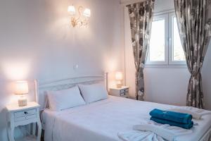 een slaapkamer met een wit bed en handdoeken bij Apartment Sofia - Beachfront in Agios Spyridon Corfu