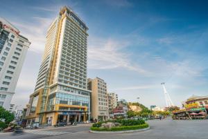 a large tall building in a city with buildings at Hotel Soleil Ha Long, Trademark Collection by Wyndham in Ha Long