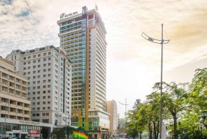 a tall building with a flag on top of it at Hotel Soleil Ha Long, Trademark Collection by Wyndham in Ha Long