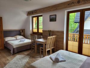 Un dormitorio con una cama y una mesa y sillas. en Willa U Zająców I, en Zakopane