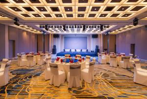 un salón de banquetes con mesas, sillas y un escenario en Hotel Soleil Ha Long, Trademark Collection by Wyndham en Ha Long