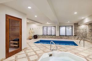 a bathroom with a swimming pool and a sink at Viana Hotel and Spa, Trademark Collection by Wyndham in Westbury