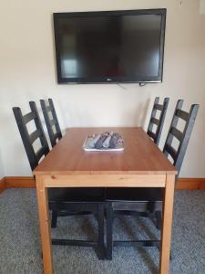 a wooden table with two chairs and a flat screen tv at Salutation Inn in Carmarthen