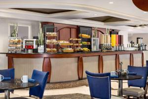 un restaurante con mesas, sillas y una barra en Viana Hotel and Spa, Trademark Collection by Wyndham, en Westbury