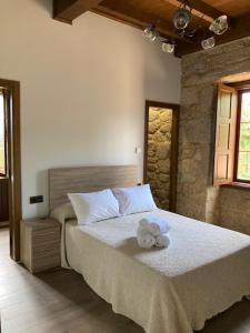 a teddy bear sitting on a bed in a bedroom at Eido do Rei - Hospedaxe rural in Ponteareas