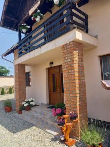 a small house with a staircase and a balcony at Casa Loredana in Cîrţişoara