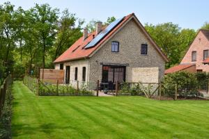 una casa con un patio con césped verde en De Kamert en Hechtel-Eksel