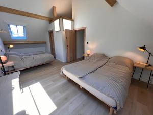 1 dormitorio con 2 camas en una habitación con suelo de madera en De Kamert, en Hechtel-Eksel