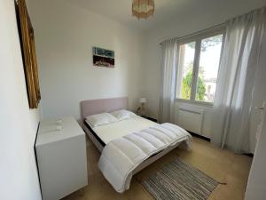 a small bedroom with a bed and a window at CAPELAN in Bandol