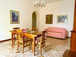 comedor con mesa y sofá rosa en Appartamento - Morciano Di Leuca, en Morciano di Leuca