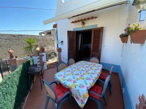 een tafel en stoelen op het balkon van een huis bij Casa Culia - Holiday Housing in Lipari