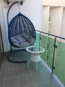 una sedia a dondolo e un tavolo sul balcone di The Fresh Wave hotel a Batumi