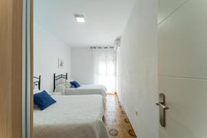 a white room with two beds and a window at Apartamento Estudio Acuario Frente Mar in Barbate