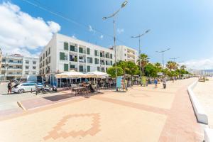 a city street with people walking and tables and buildings at Apartamento Estudio Acuario Frente Mar in Barbate