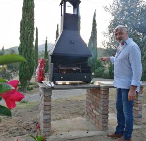 ein Mann steht vor einem Außengrill in der Unterkunft Agriturismo Il Marrucheto in Scala Santa
