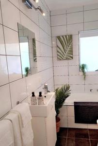 Un baño blanco con lavabo y espejo. en The Sea Haven 200m to Henley Beach, en Henley Beach South 22 fotos más