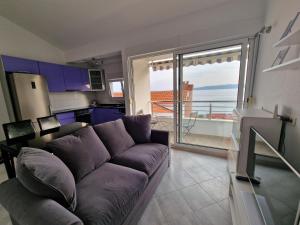 uma sala de estar com um sofá e uma grande janela em Apartment NiNa em Baska Voda
