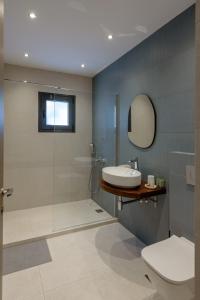 a bathroom with a shower and a sink and a toilet at Galio Suites Airport by Airstay in Spata