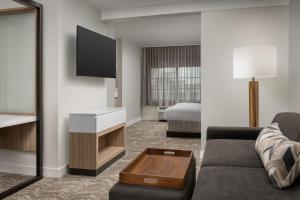 une chambre d'hôtel avec un canapé et un lit dans l'établissement SpringHill Suites by Marriott Atlanta Buford/Mall of Georgia, à Buford