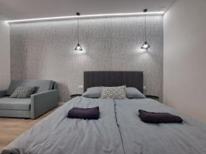 - une chambre avec un grand lit et un canapé dans l'établissement Belvárosi Lux Apartman, à Vásárosnamény