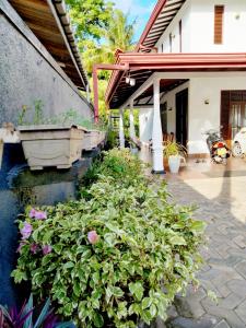 a garden with flowers and a house with a tub at A2+villa in Weligama