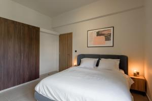 a bedroom with a large white bed with two lamps at Galio Suites Airport by Airstay in Spata