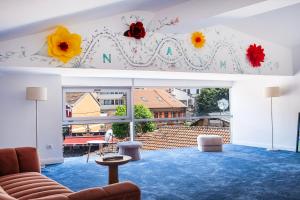una sala de estar con un mural de flores en la pared en Nam Hotel, en Prizren