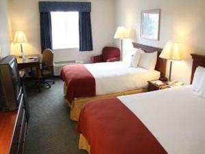 a hotel room with two beds and a television at Baymont by Wyndham Rolla in Rolla