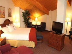 Baymont by Wyndham Rolla في رولا: غرفة فندقية بسرير وتلفزيون بشاشة مسطحة
