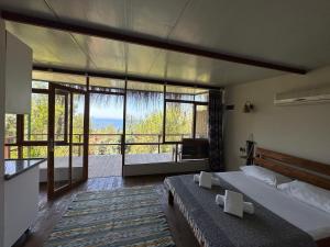 a bedroom with a large bed and a large window at Honey Hill Faralya Forest Cabins by the Sea in Faralya