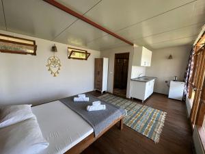 a bedroom with a large bed and a kitchen at Honey Hill Faralya Forest Cabins by the Sea in Faralya