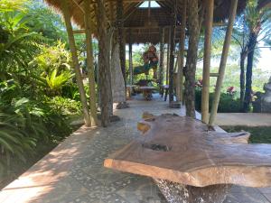 un banco de madera sentado bajo un pabellón en un jardín en Lembah Cinta Mayungan, en Baturiti