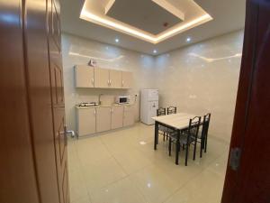 a kitchen and dining room with a table and chairs at Lona Park in Taif
