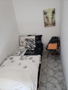 a bed with black and white sheets and a chair at Comfy zone in Abu Dhabi
