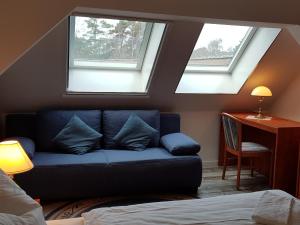 ein Wohnzimmer mit einem blauen Sofa und 2 Fenstern in der Unterkunft Parkresidenz Dierhagen in Dierhagen