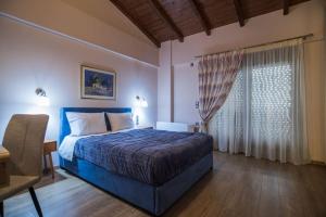 a bedroom with a blue bed and a window at Modern, Stylish Maisonette in Itea