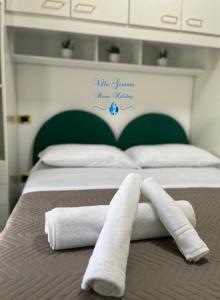 Una cama con dos toallas encima. en Villa Gemma, en Campomarino