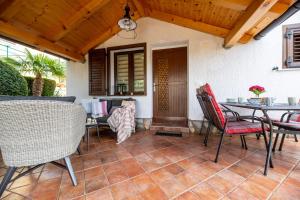 a patio with a table and chairs and a dining room at Apartman "ELA" in Njivice